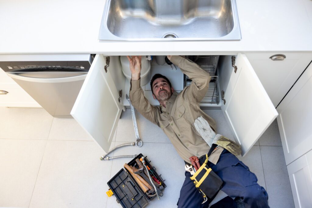 Plumber fixing kitchen sink